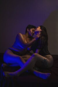 women being intimate in blue lighting